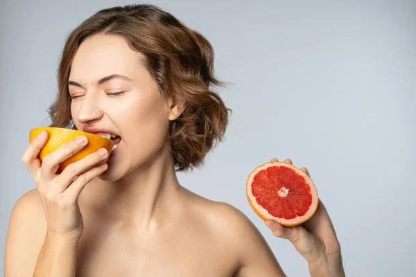 Female holding two halves of citrus fruit — Stock Photo, Image