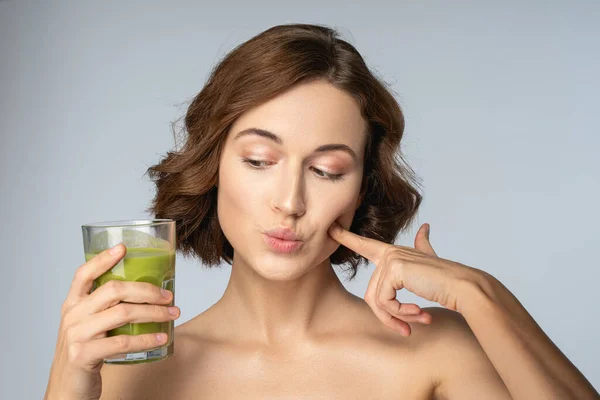 Vacker ung kvinna med en grön smoothie — Stockfoto