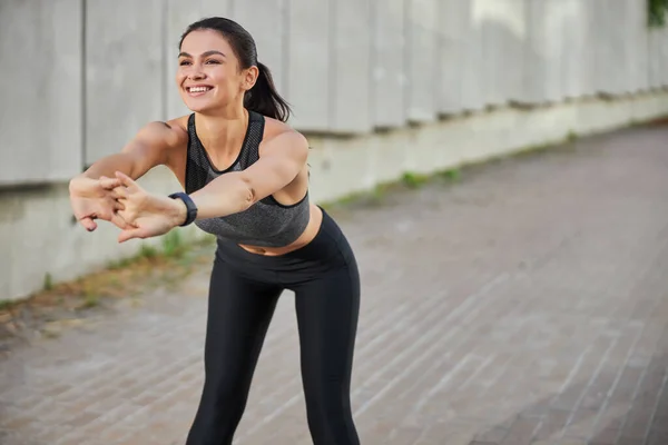 Радостная молодая женщина занимается фитнесом на открытом воздухе — стоковое фото