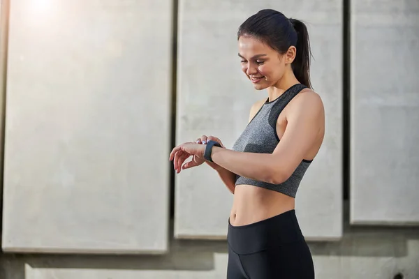 Positive delighted young female person checking time — Stock Photo, Image