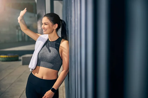 Positiva mujer joven encantada agitando su mano — Foto de Stock