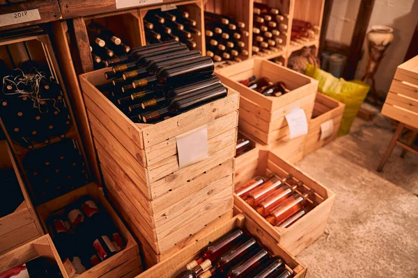 Caixas de madeira com garrafas de vinho na sala de armazenamento — Fotografia de Stock