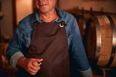 Unrecognized male sommelier in apron and denim shirt clipart