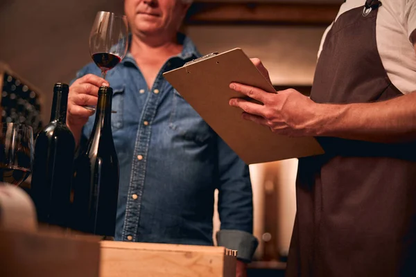 Sommelier professionisti che valutano il vino rosso e prendono appunti — Foto Stock