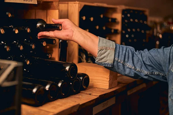 Fileiras de garrafas de vinho em prateleiras de madeira com anos escritos — Fotografia de Stock