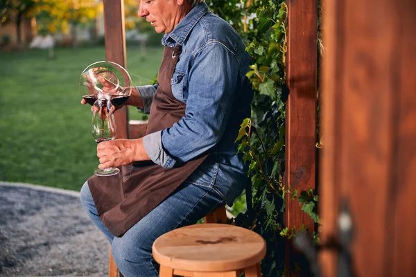 Осторожный сомелье наливает вино в графин на открытом воздухе — стоковое фото