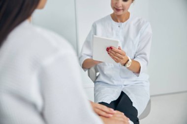 Müvekkilinin yanında oturan bir aletle dermatolog.