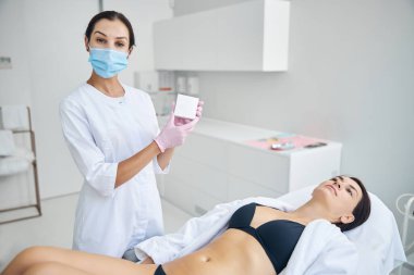 Doktor elinde doku örneğiyle biyopsi kaseti tutuyor.