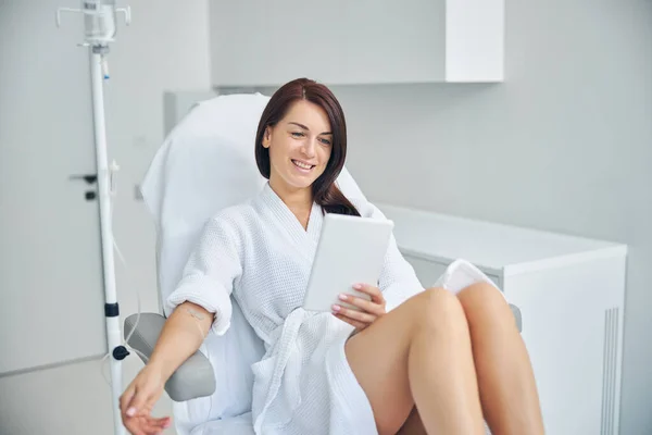 Pleased female patient using a tablet computer — Stock Photo, Image