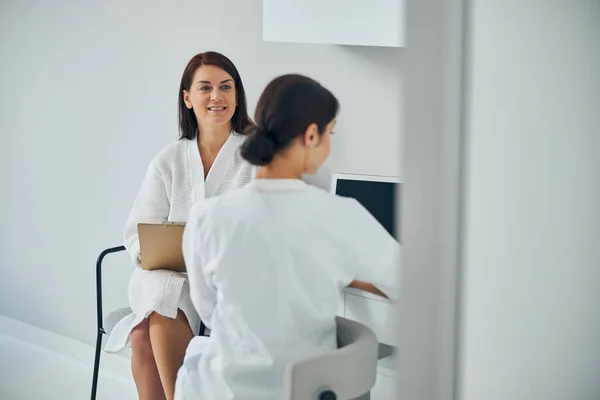 Плідна жінка-пацієнтка має консультацію з косметологом — стокове фото