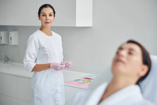 Dermatóloga tranquila lista para tratar a su paciente — Foto de Stock