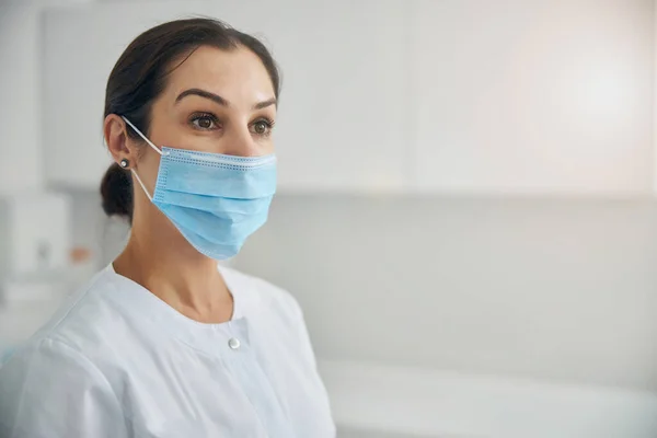 Hautärztin im Laborkittel steht drinnen — Stockfoto