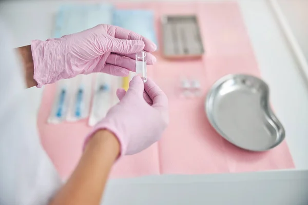 Manos en guantes desechables con un vial sellado —  Fotos de Stock