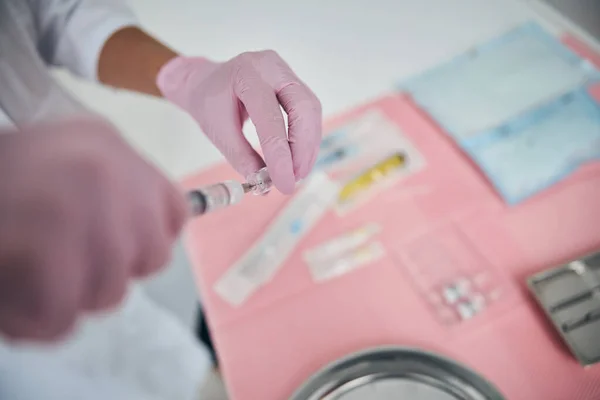 Médico sosteniendo un vial con líquido para inyección —  Fotos de Stock