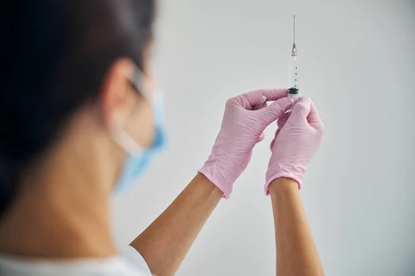 Dermatologue dans un masque facial se préparant à faire une injection — Photo