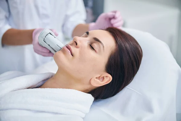 Beautiful lady with eyes closed undergoing a cosmetic procedure — Stock Photo, Image