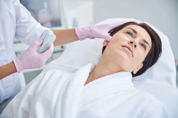 Спокійна нахабна жінка дивиться під час перевірки шкіри — стокове фото