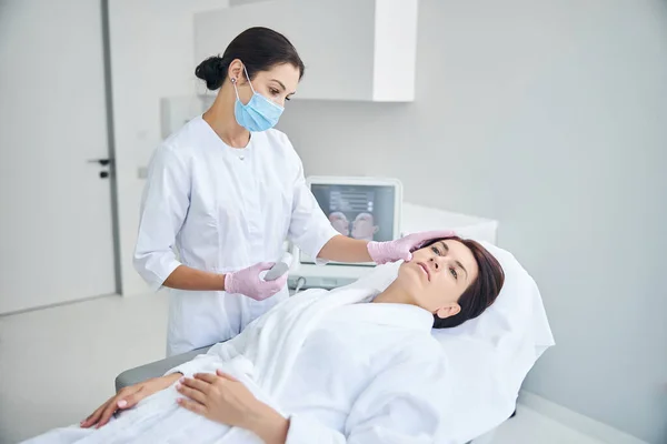 Dermatologista qualificado em luvas estéreis examinando o paciente — Fotografia de Stock