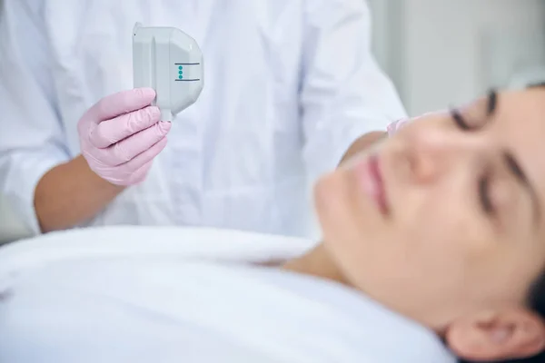 Dermatologista experiente em luvas de látex examinando uma mulher — Fotografia de Stock