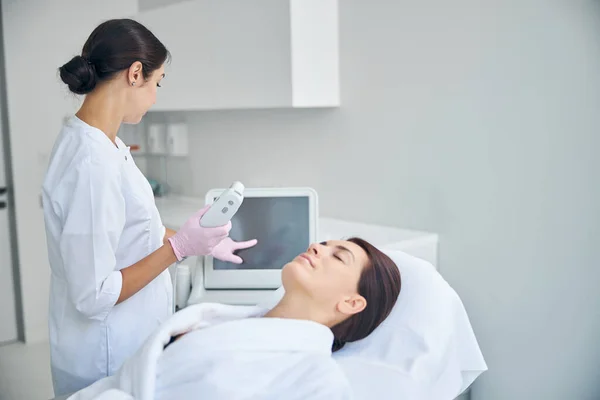 Dermatólogo preparando a un paciente para un tratamiento de ultrasonido — Foto de Stock