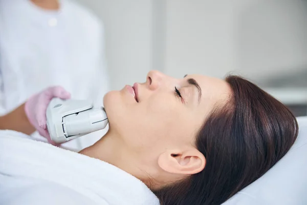 Kobieta relaksująca się podczas ultradźwiękowej terapii wykonywanej przez kosmetyczkę — Zdjęcie stockowe