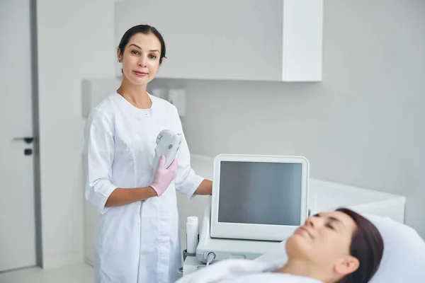 Entspannte Kosmetikerin bereit für die Behandlung ihrer Patientenhaut — Stockfoto