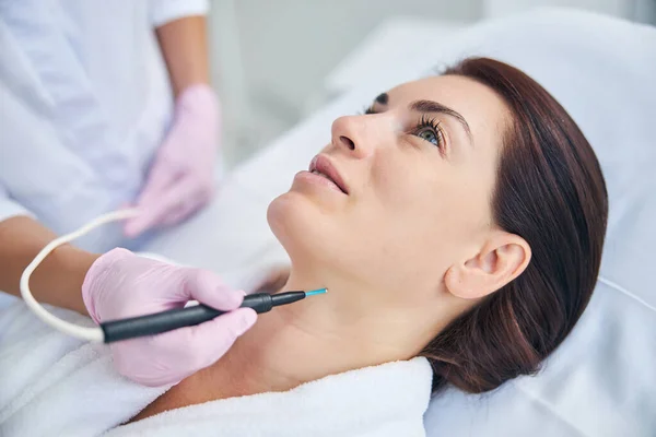 Cosmetician using an electrocautery machine for removing a nevus — Stock Photo, Image