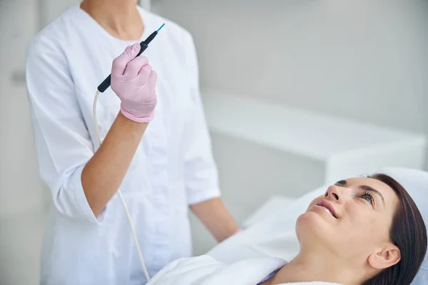 Zufriedene Frau wird von einem professionellen Dermatologen behandelt — Stockfoto