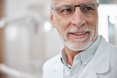 Neşeli doktor gülümsüyor ve yan tarafa bakıyor