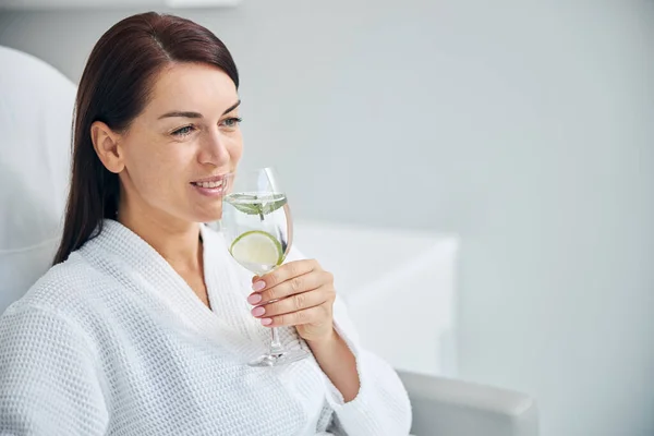Usmívající se lázeňský klient se sklenkou zdravého nápoje — Stock fotografie