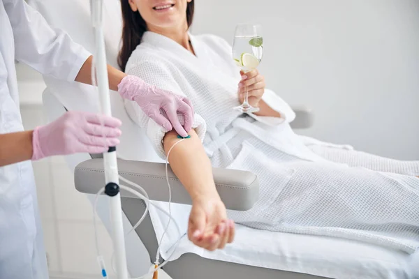 Smiling female patient undergoing intravenous vitamin therapy — Stock Photo, Image