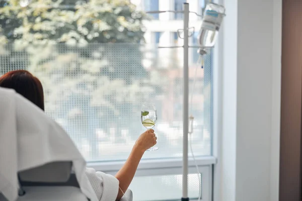 Kvinna med ett glas dryck som genomgår ett medicinskt ingrepp — Stockfoto