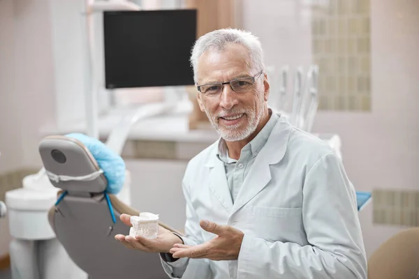 Dentista profesional que demuestra un molde de yeso personalizado de los dientes —  Fotos de Stock