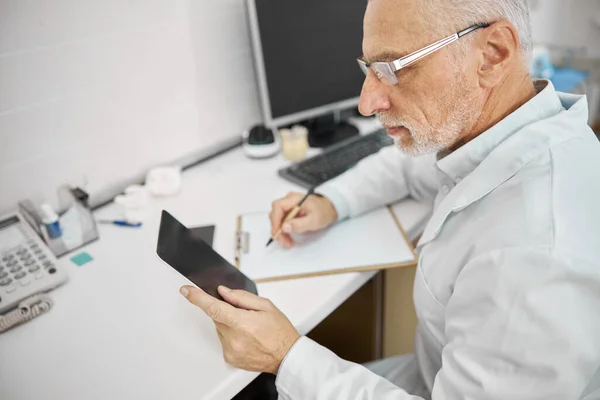 Upptagen pensionär som arbetar på en klinik — Stockfoto