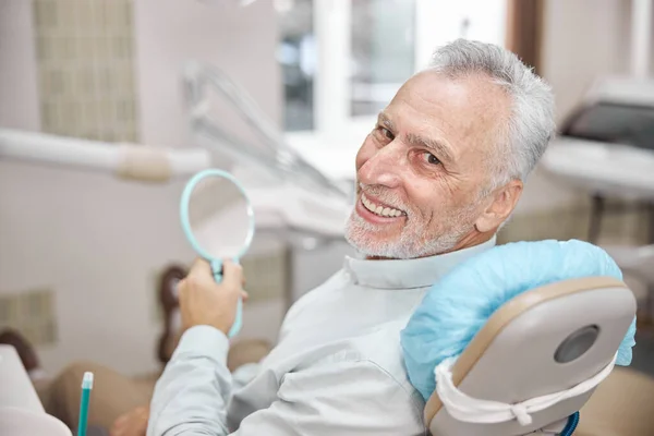 Hombre envejecido que parece satisfecho con su cita dental — Foto de Stock