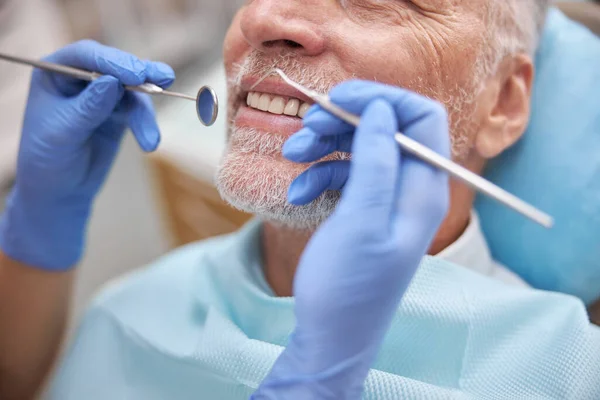 Eldelry hombre sonriendo durante una cita dental — Foto de Stock