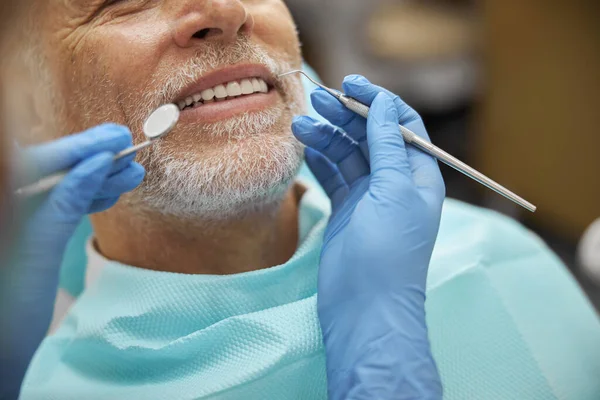 长者在牙科诊所检查时面带微笑保持镇定 — 图库照片