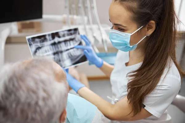 Dentista profesional sosteniendo una radiografía dental de su paciente — Foto de Stock