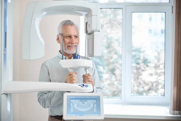 Paciente anciano recibiendo una radiografía dental panorámica — Foto de Stock