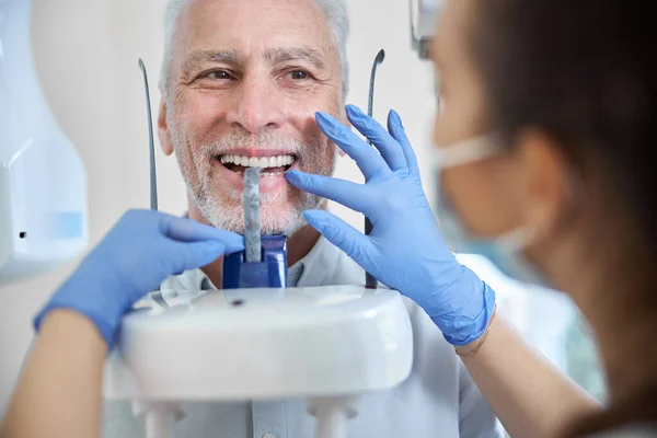 Hombre envejecido examinándose los dientes en una máquina de rayos X panorámica — Foto de Stock