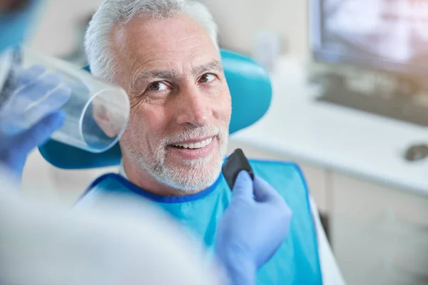 Hombre de edad sonriente preparándose para una radiografía dental — Foto de Stock