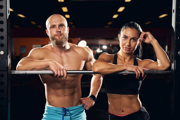 Hombre bien construido y su novia fuerte posando en el gimnasio —  Fotos de Stock