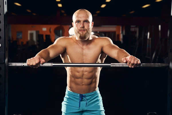 Shirtless sportsman standing next to a barbell — Stock Photo, Image