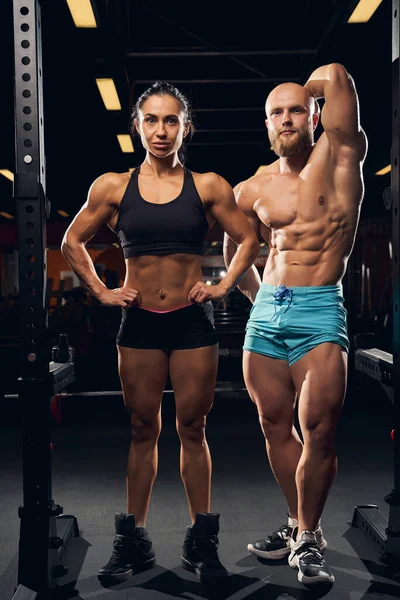 Dos jóvenes culturistas atléticos de pie en el gimnasio — Foto de Stock