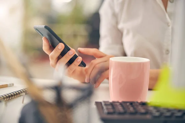 Primer plano del teléfono en la mano femenina —  Fotos de Stock