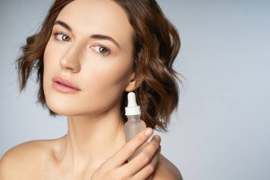 Cildinde vitamin serumu olan çekici genç bir kadın.