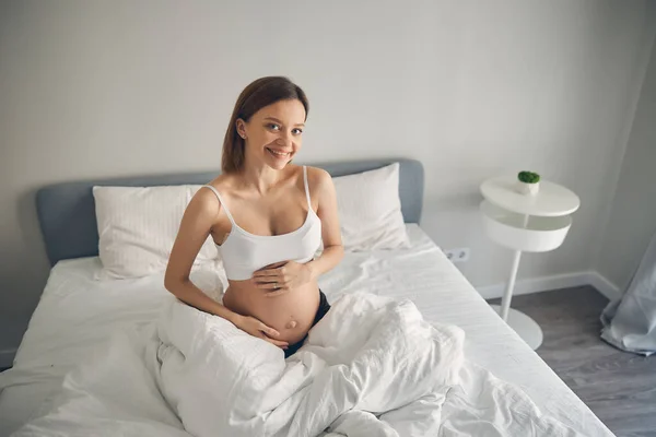 Сентиментальная беременная женщина в элегантном интерьере — стоковое фото