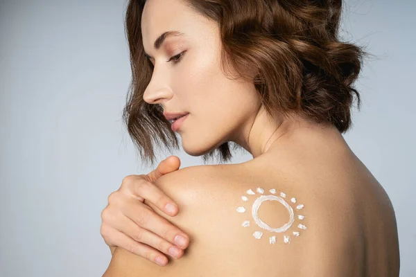 Hermosa mujer joven mostrando la forma del sol en su piel — Foto de Stock