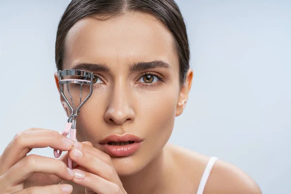 Beautiful young woman with perfect skin using eyelash curler — Stock Photo, Image