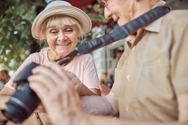 Kameralı bir adamın yanında oturan hoş bayan.